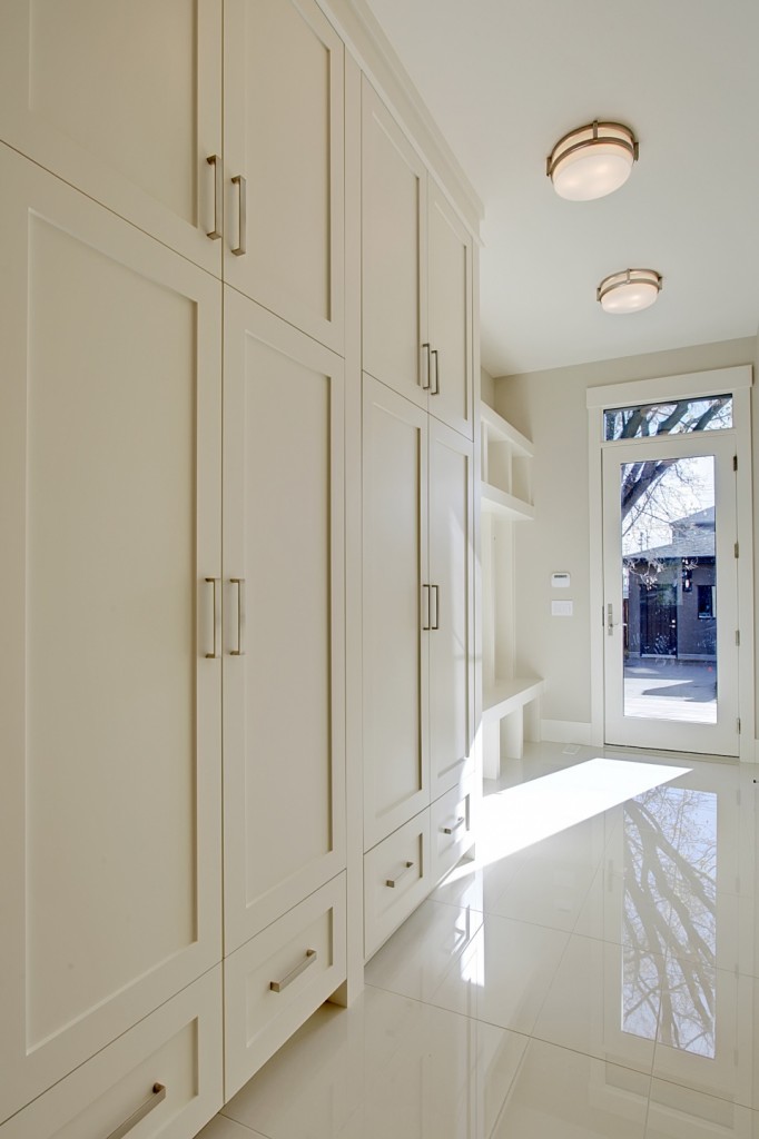 White mudroom cabinetry with full-height storage and bench seating