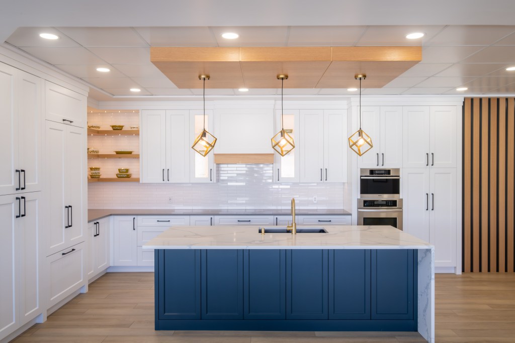 White custom kitchen with a navy island and geometric pendant lights